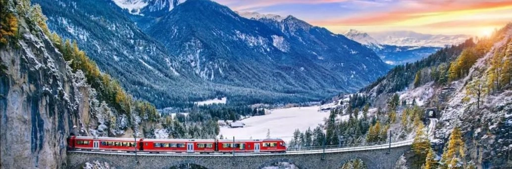 Vonat halad át egy szép hídon a hegyek között