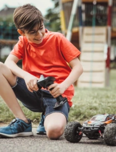 A kisfiú távirányítós autóval játszik
