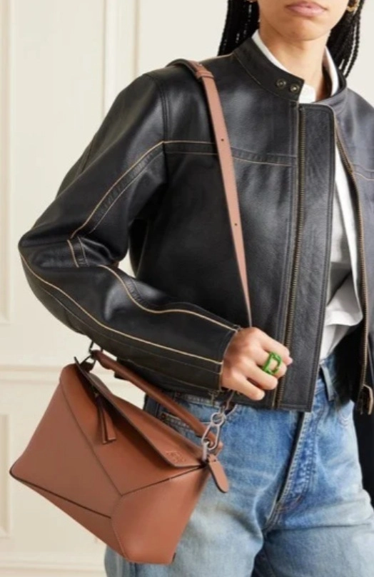 Nő divatos kabátban, barna válltáskával