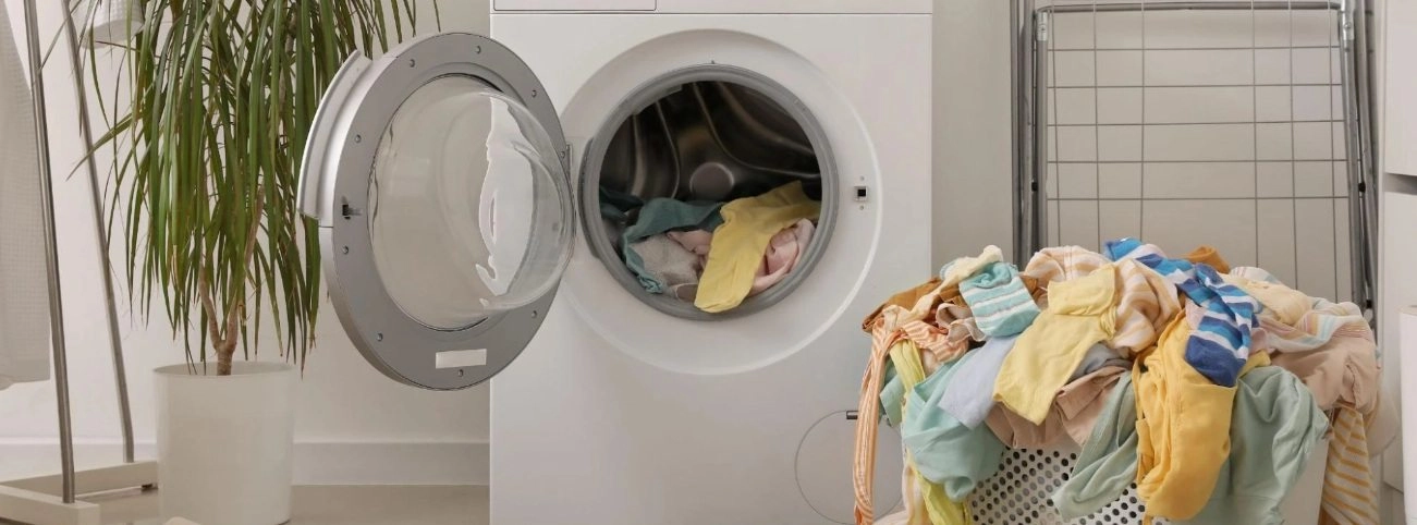 Mosógép és mosatlan ruhák