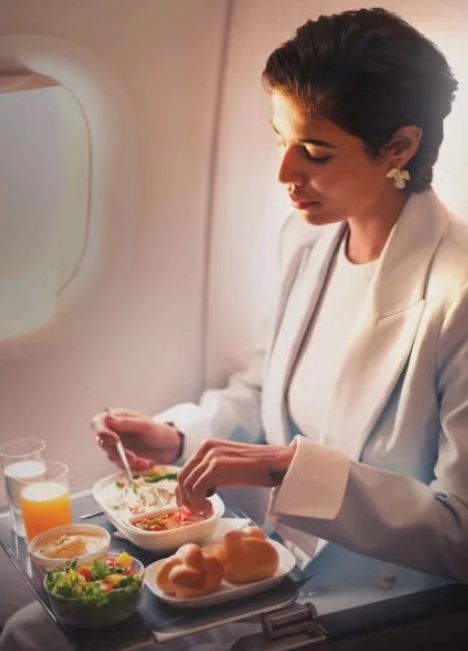 A nő a repülőgép fedélzetén étkezik