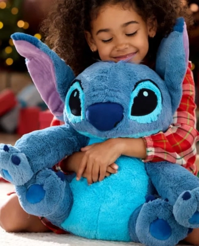 A kislány hatalmas Stitch plüssöt ölelget