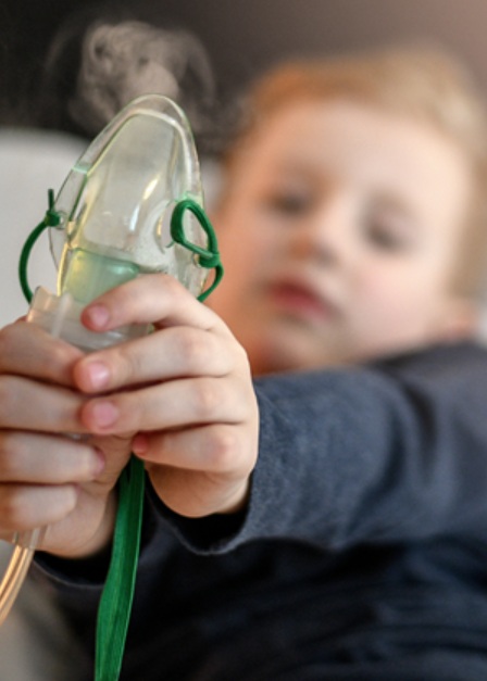 A kisgyermek inhalátort tart a kezében