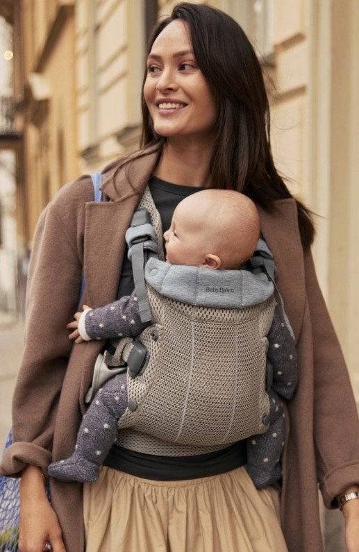 Az anya a babahordozóban viszi a kisbabáját