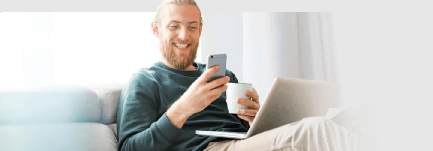A férfi laptopot és mobiltelefont használ