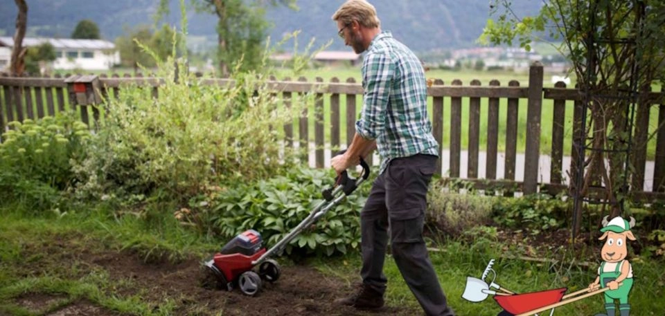 A férfi talajlazítót használ a kertben