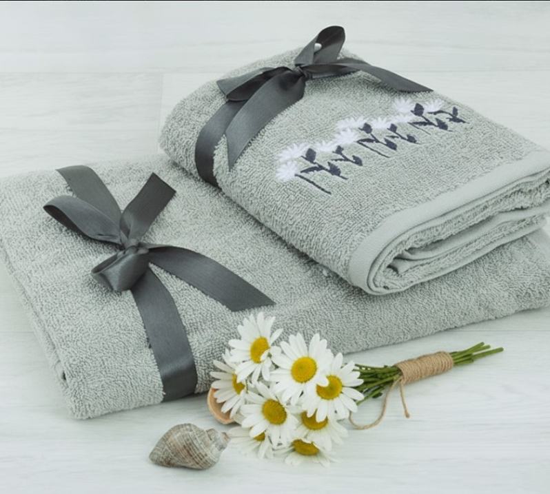 Két törölköző átkötve masnival és virág