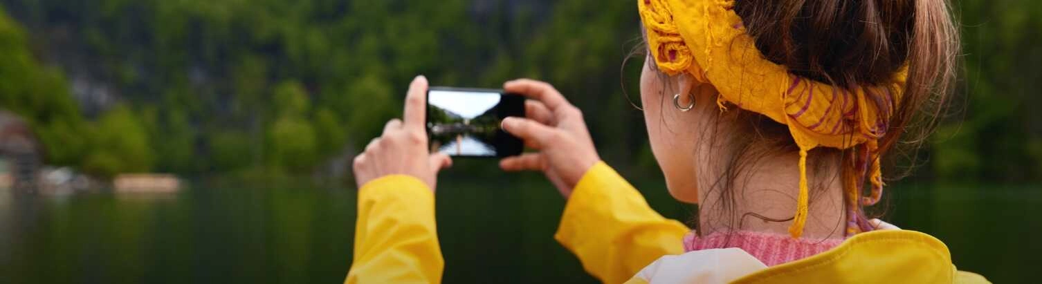 A nő tájképet készít a tóról és az erdőről