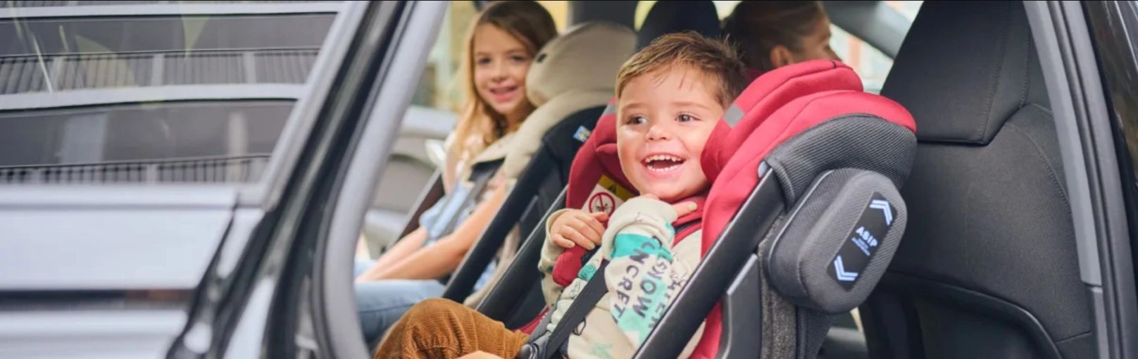 A gyerekek az autósülésben ülnek és mosolyognak